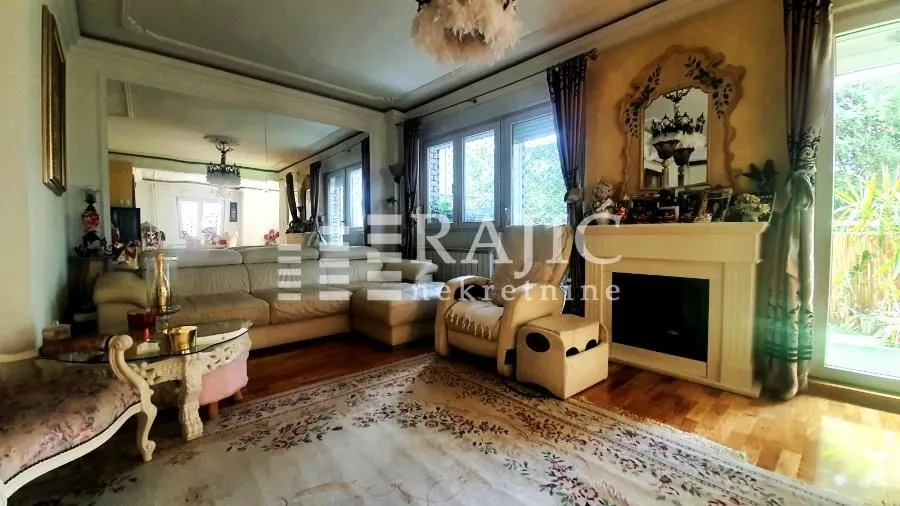 Spacious living room with a sofa set, fireplace, and a large wall mirror.
