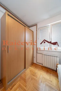 Small bedroom with a large wooden wardrobe, parquet flooring and a window. - image 13
