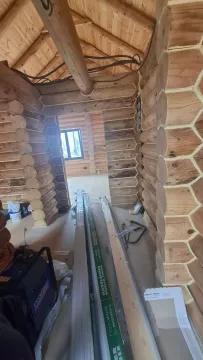 Interior of a log cabin under construction with wooden walls and beams. - image 18