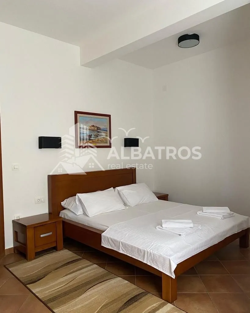 Bedroom with a double bed, wooden nightstands, and a painting on the wall.
