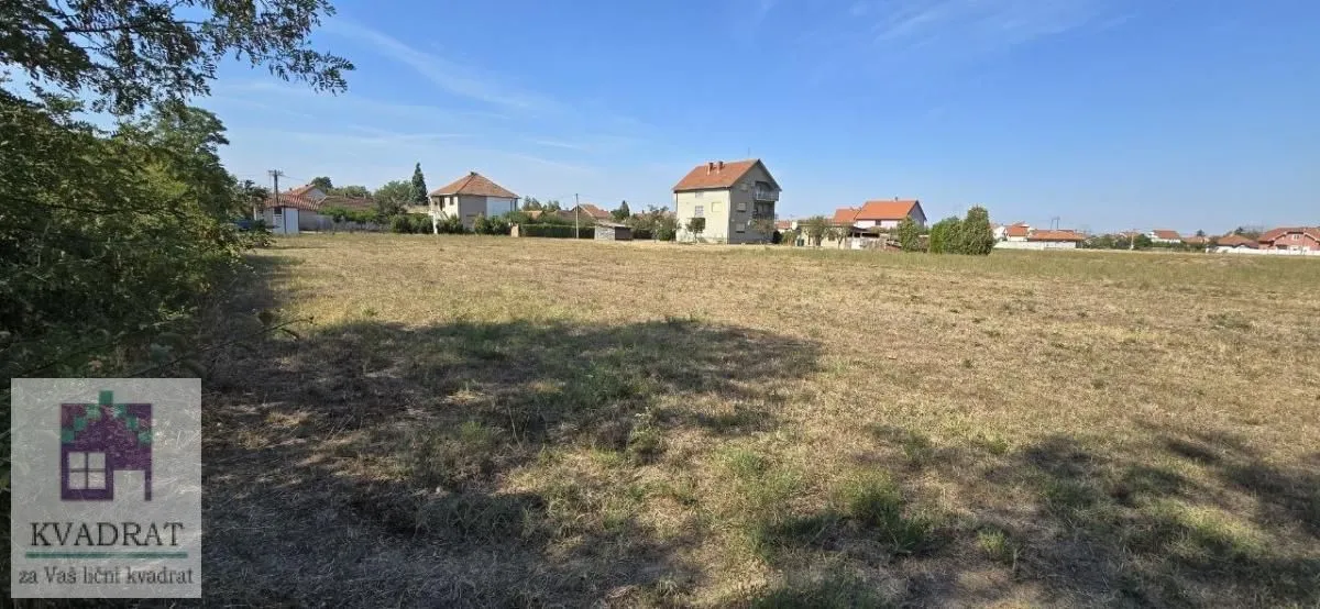 Pogled na prostrano zemljište sa okolnim kućama u pozadini.