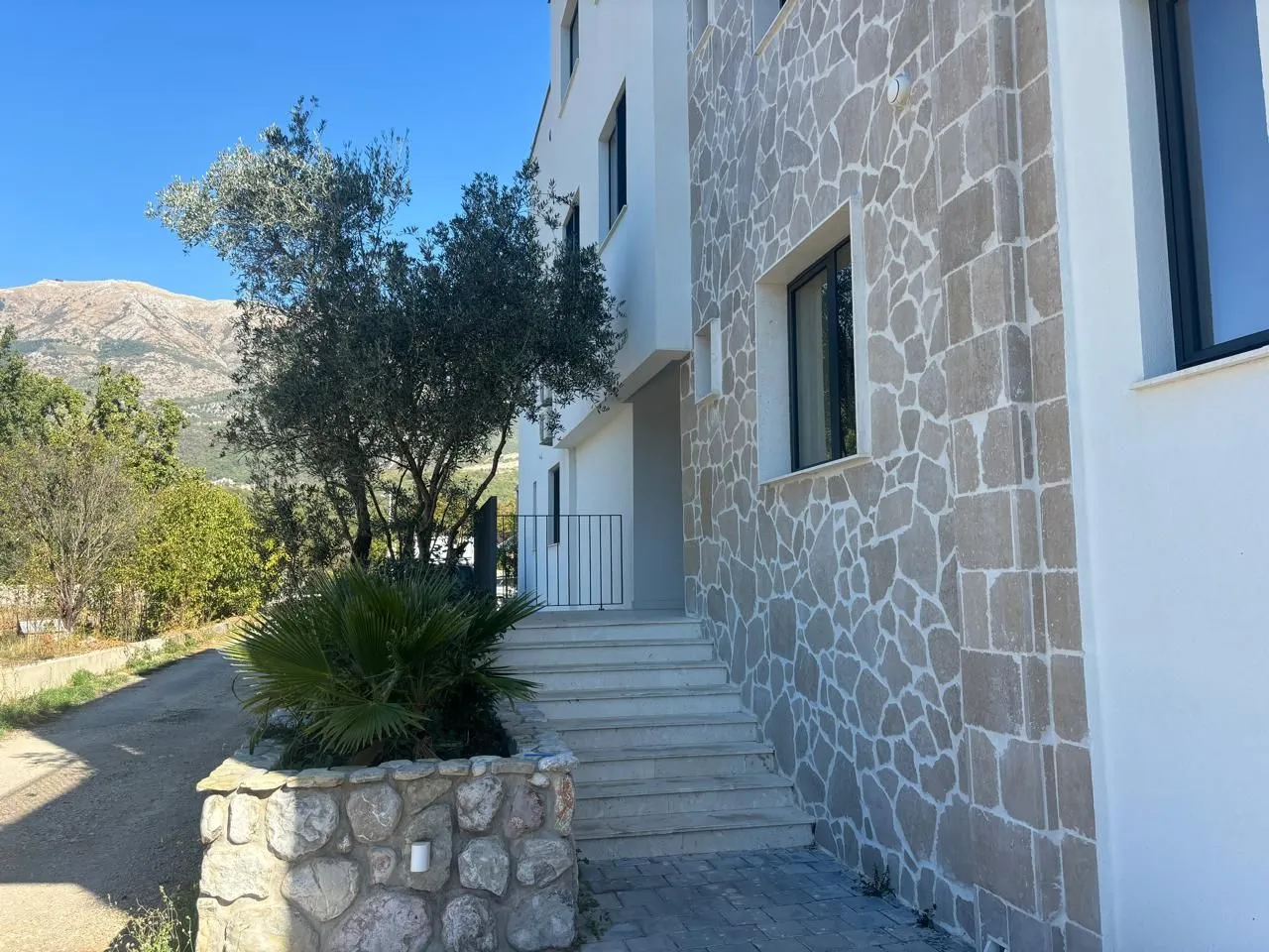 Exterior of the building with a stone facade and entrance stairs.
