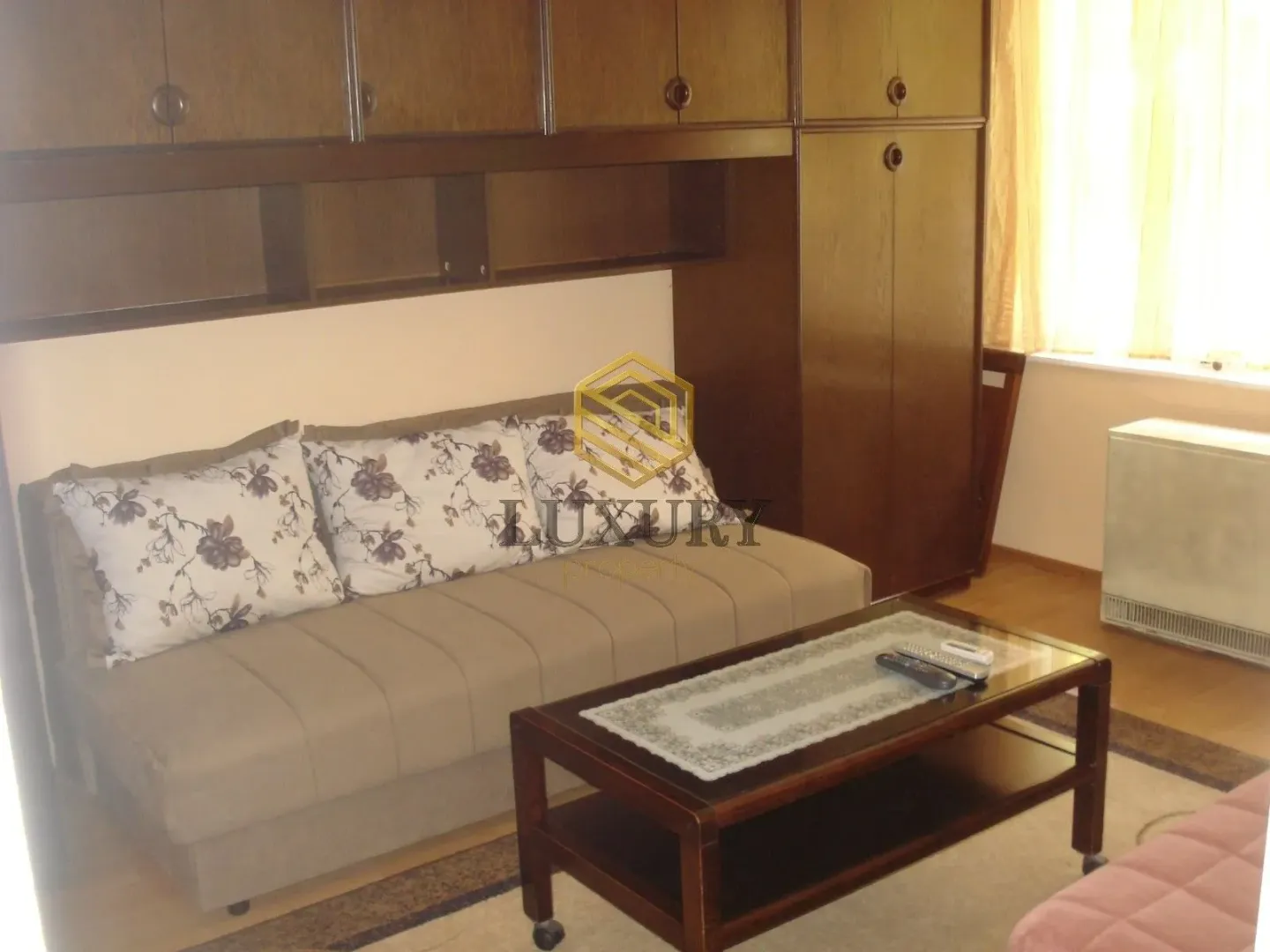 Living room with a sofa, wooden furniture, and a coffee table.