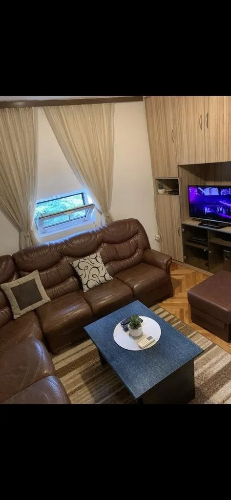 Living room with a leather sofa set, coffee table, and television.