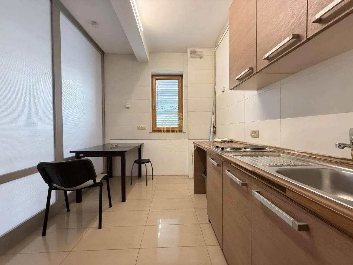 Kitchen with wooden cabinetry and a dining table with chairs by the window.