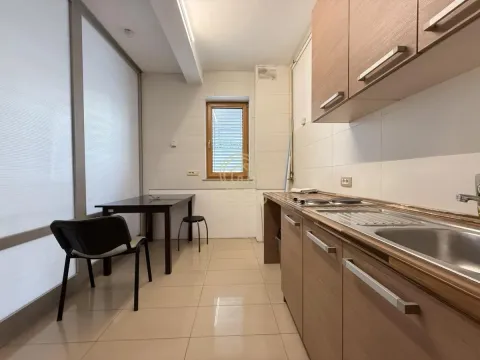 Kitchen with wooden cabinetry and a dining table with chairs by the window. - image 2