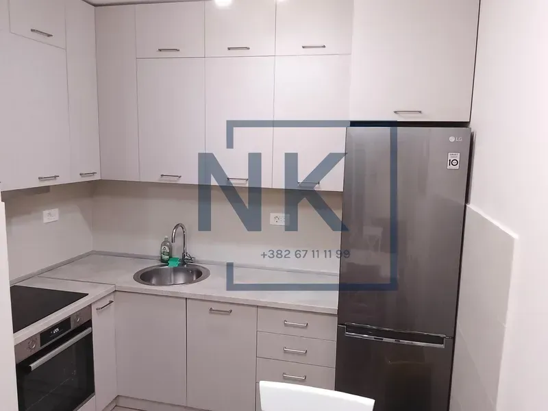 Small kitchen with white cabinets and a refrigerator.
