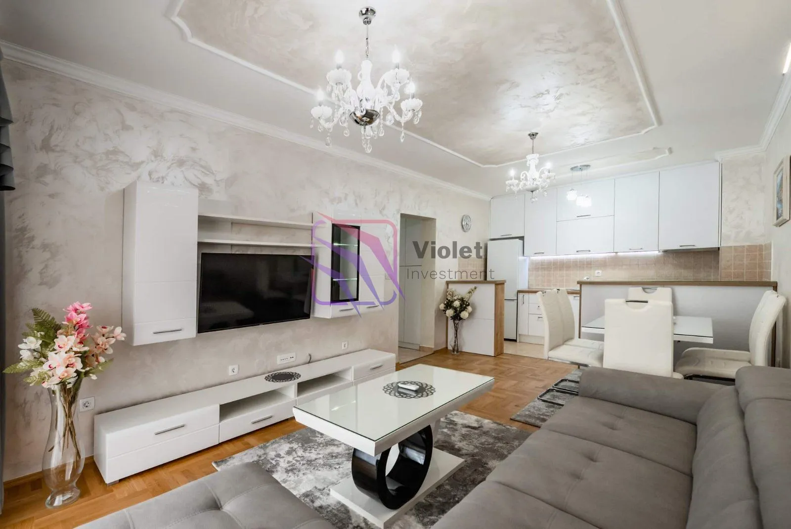 Living room with a sofa and TV connected to the kitchen.
