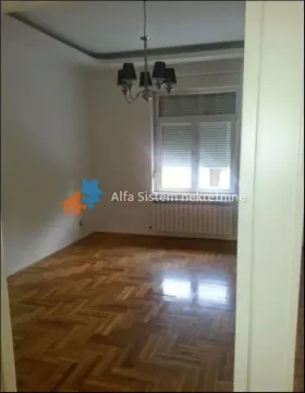 Empty room with parquet flooring and a chandelier. - image 3
