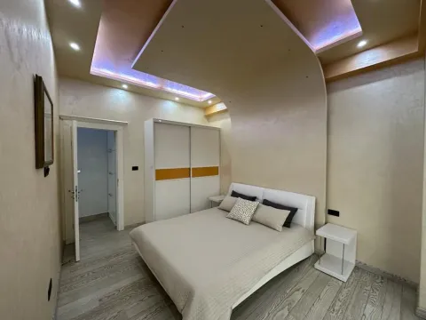 Furnished bedroom with a double bed, wardrobe, and a dropped ceiling with lighting. - image 6