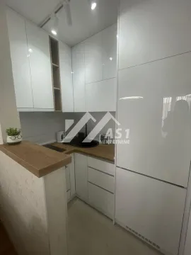 Moderna bela kuhinja sa drvenim radnim površinama. - image 3