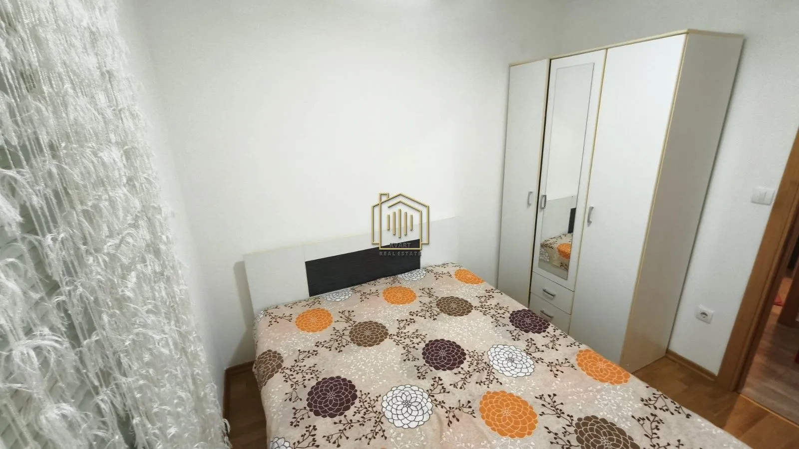 Furnished bedroom with a double bed and a wardrobe.