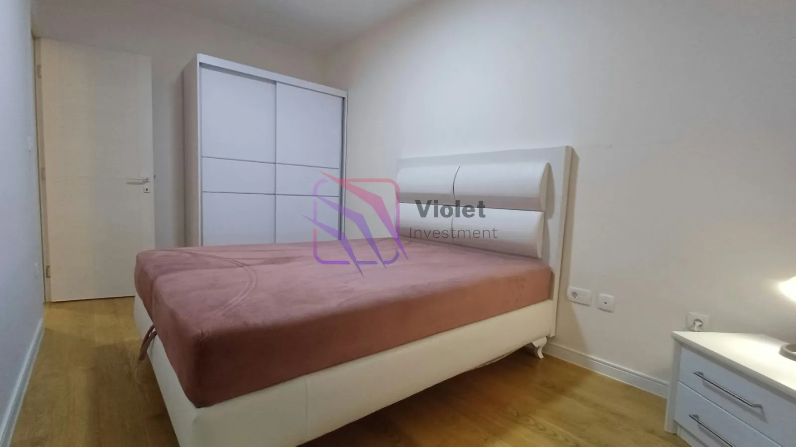 Bedroom with a double bed, white wardrobe, and a nightstand.