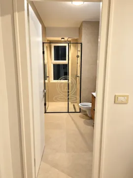 View from the hallway into a modern bathroom with a walk-in shower. - image 7