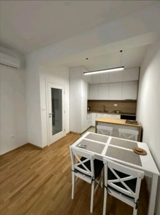 Small kitchen with a dining table and white cabinets.