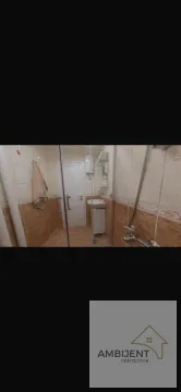 Kupatilo obloženo keramičkim pločicama sa tuš kabinom i umivaonikom. - image 5