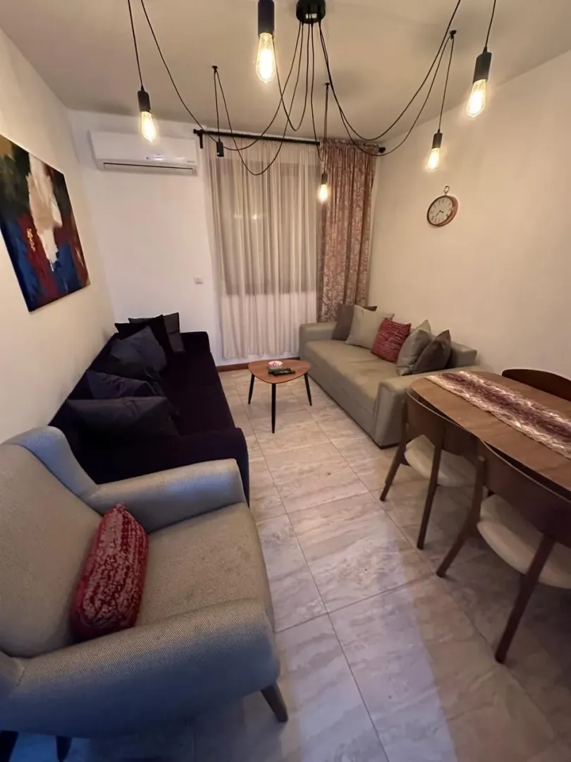 Living room with sofa set, armchair, and dining table.
