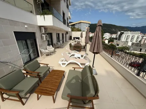 Large terrace with seating furniture, sun loungers, and a city view. - image 7