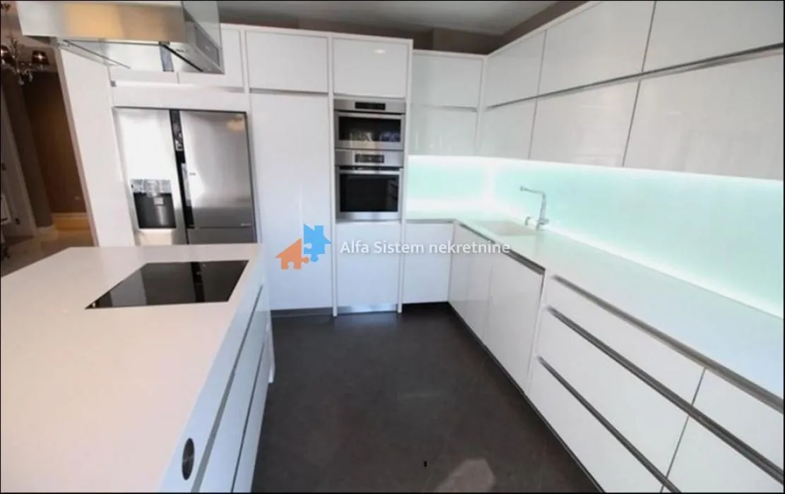 Modern white kitchen with an island and built-in appliances.