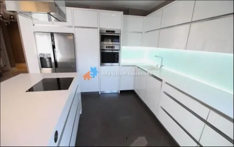 Modern white kitchen with an island and built-in appliances. - image 5