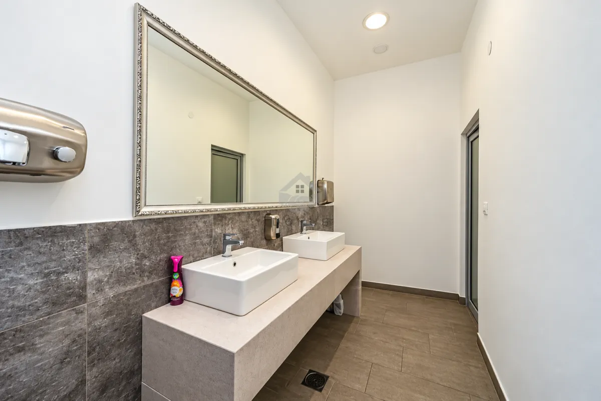 Modern bathroom with two sinks and a large mirror.