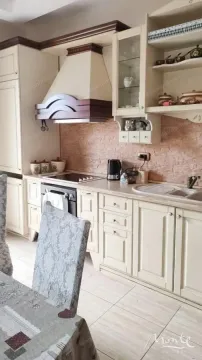 Traditional kitchen with beige cabinetry and built-in appliances. - image 7
