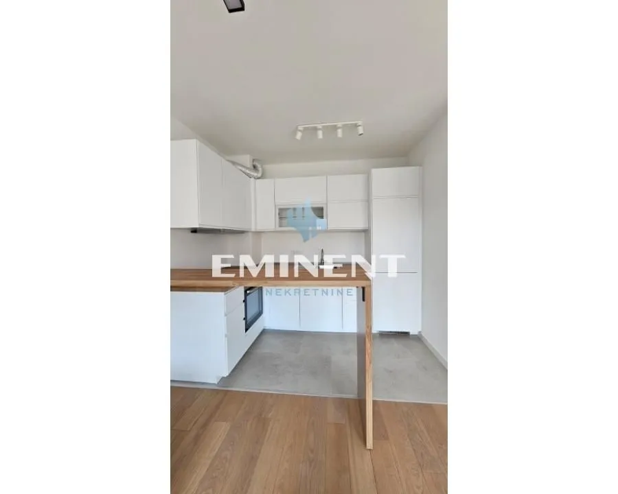 Moderna bela kuhinja sa drvenim radnim elementima.