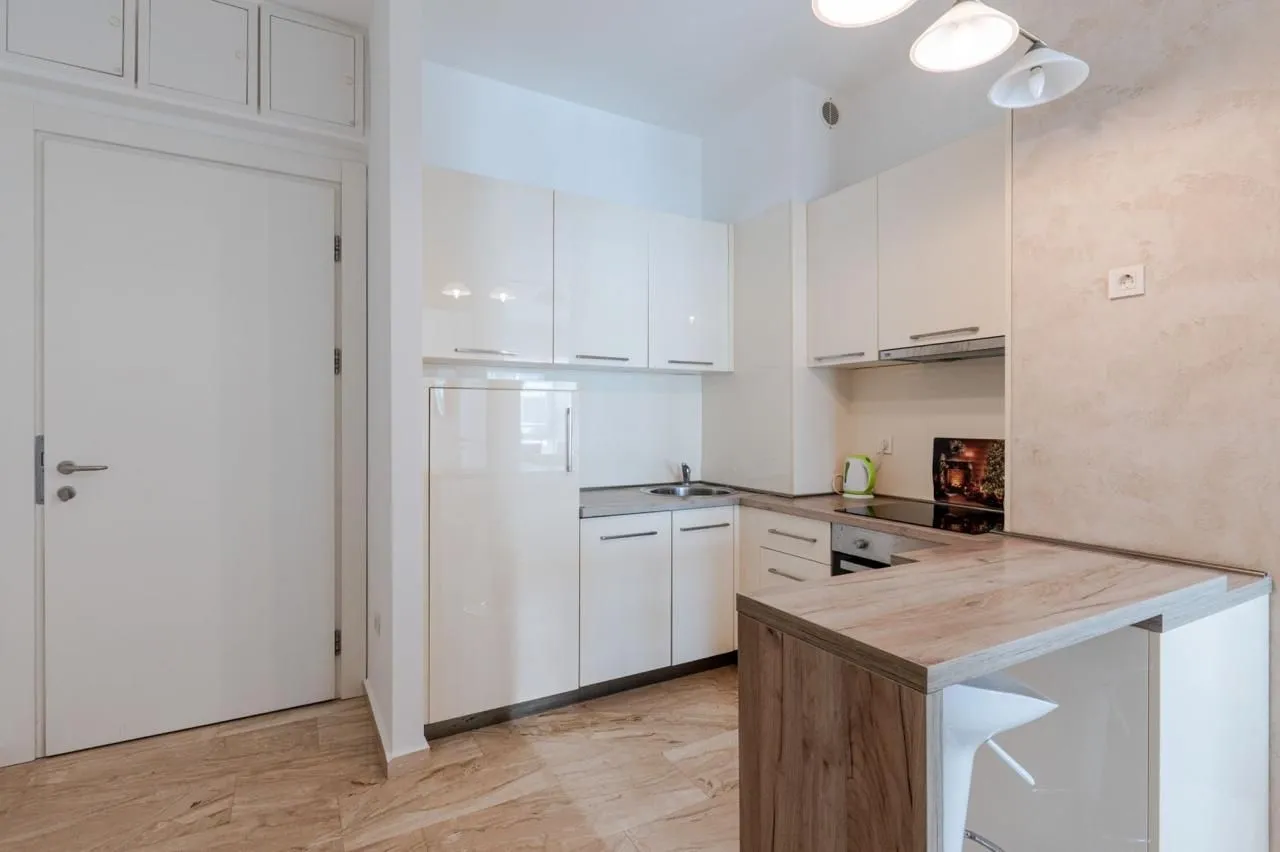 Small modern kitchen with white cabinets and a breakfast bar.