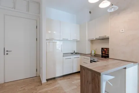 Small modern kitchen with white cabinets and a breakfast bar. - image 4