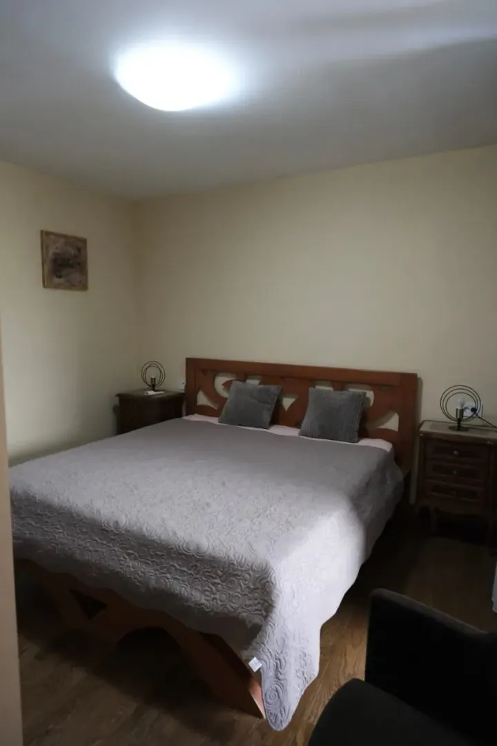 A simply furnished bedroom with a double bed and nightstands.
