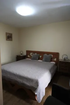 A simply furnished bedroom with a double bed and nightstands. - image 13