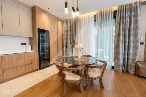 Dining area with a round table and chairs, situated next to the kitchen section with wooden elements. - image 2