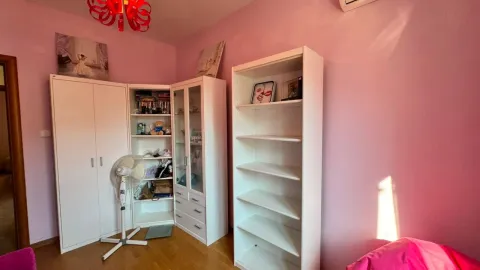 Dječija soba sa bijelim ormarima i roze zidovima. - image 6
