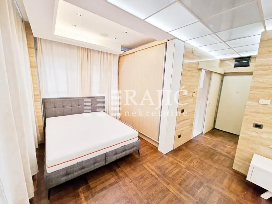 Bedroom with a double bed, large wardrobe, and parquet flooring.