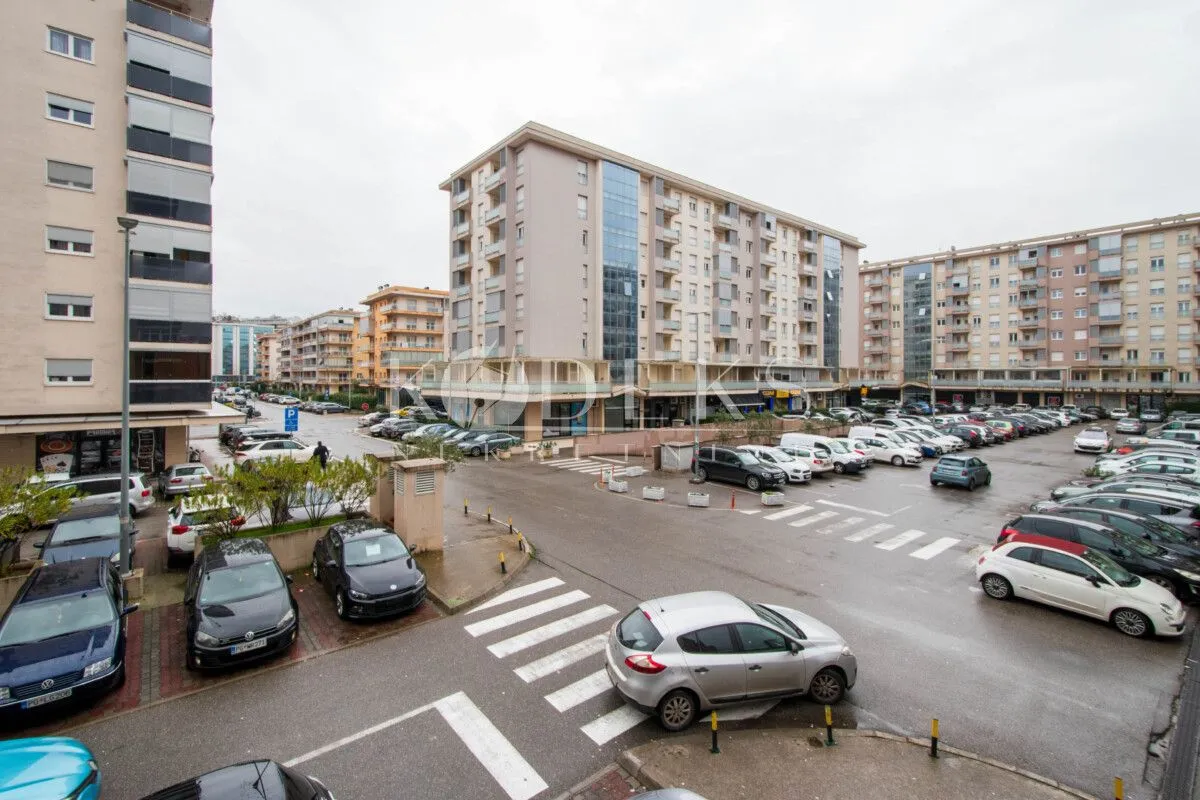 High-angle view of the street, buildings, and parking lot in front of the residential block.