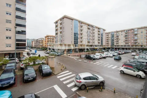 High-angle view of the street, buildings, and parking lot in front of the residential block. - image 12