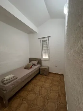 Manja spavaća soba sa krevetom i noćnim stočićem. - image 8