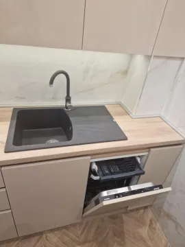 Deo kuhinje sa sudoperom i otvorenom mašinom za pranje sudova. - image 11