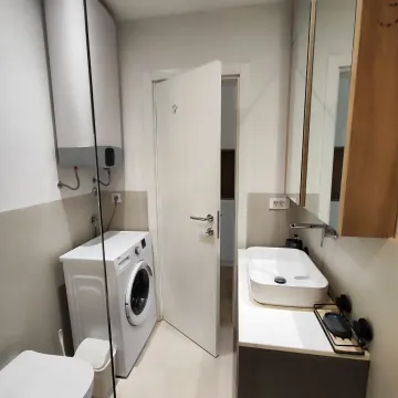Savremeno opremljeno kupatilo sa umivaonikom, veš mašinom i bojlerom. - image 8