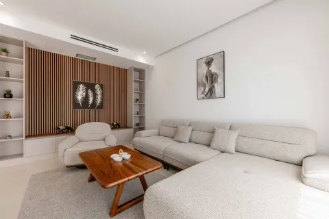 Living room with a sectional sofa, wooden coffee table, and decorative wall panels. - image 18