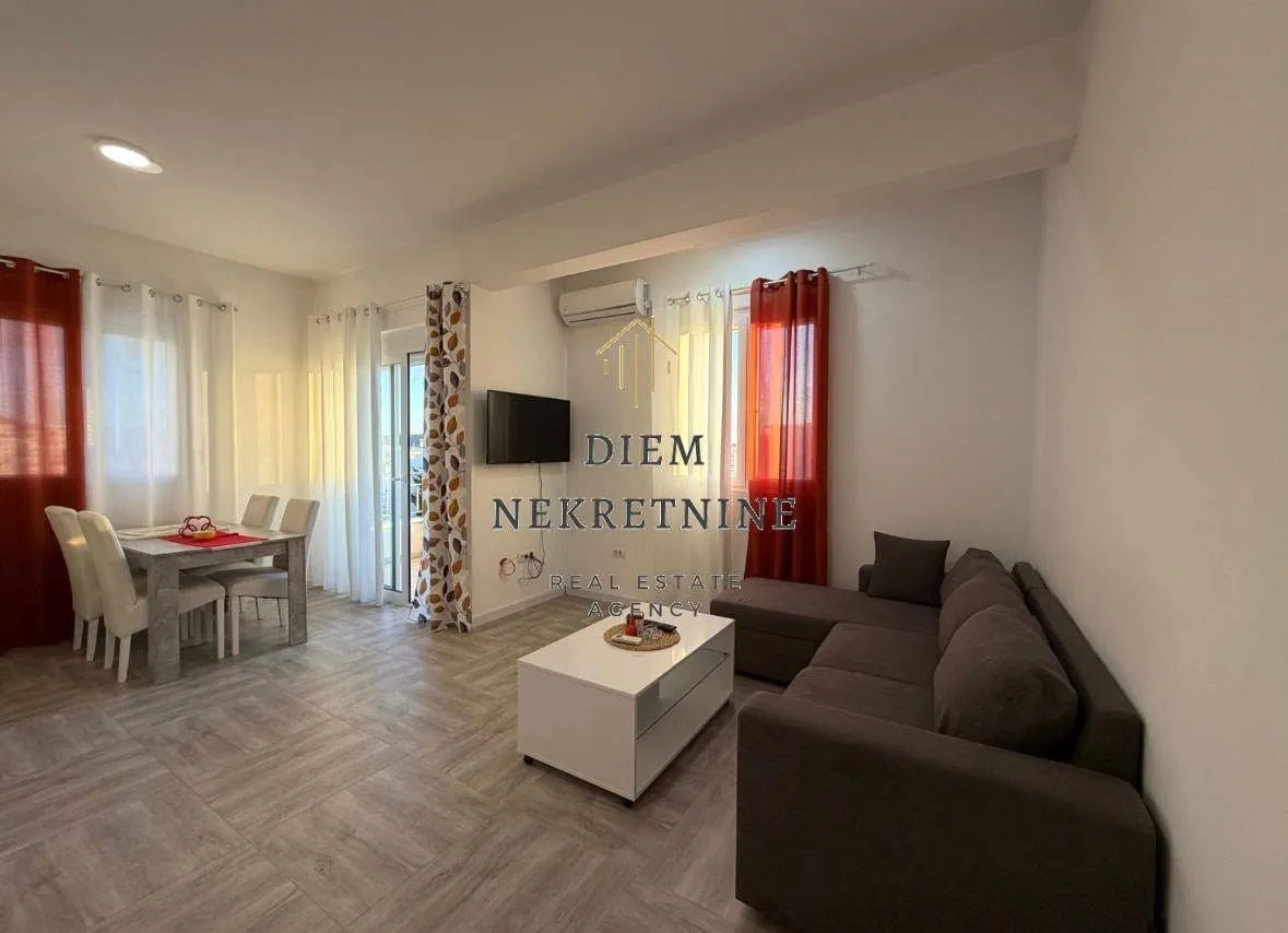 Spacious living room with a corner sofa, dining area, and terrace access.