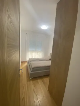 Svijetla spavaća soba sa bračnim krevetom viđena kroz otvorena vrata. - image 6