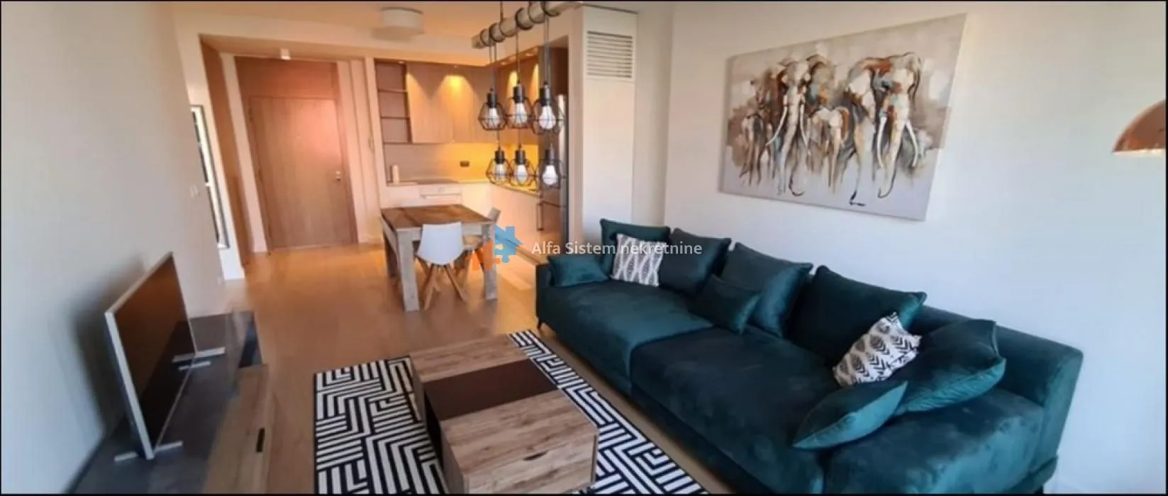 Living room with a sofa and dining area in the background.