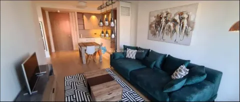 Living room with a sofa and dining area in the background. - image 2