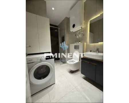 Modern bathroom with a walk-in shower, washbasin, toilet, and washing machine. - image 5