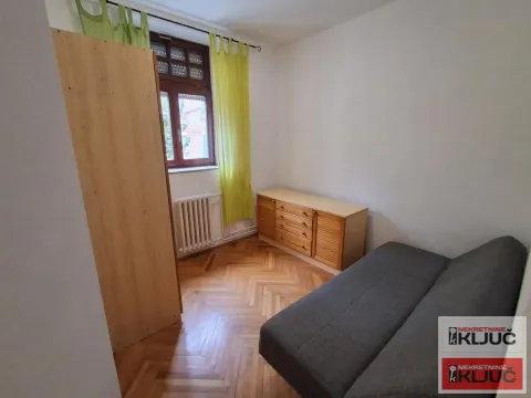 Manja spavaća soba sa krevetom na razvlačenje i drvenim nameštajem. - image 7