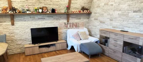 Dnevna soba sa televizorom, foteljom i zidnom oblogom od kamena. - image 12