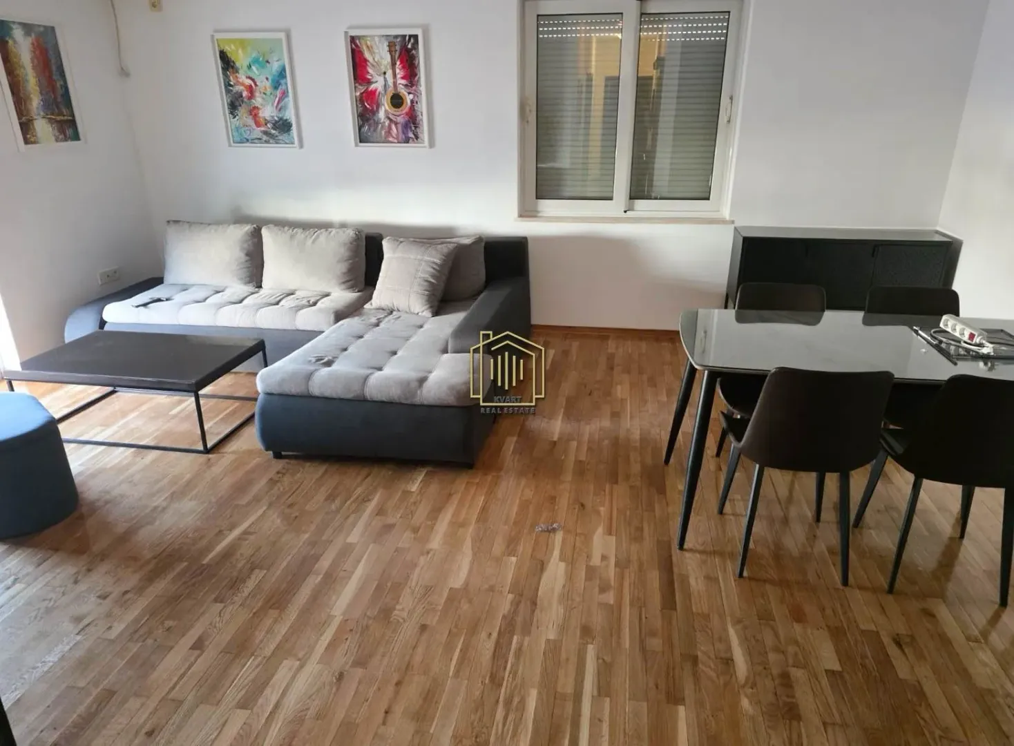 Dnevna soba sa garniturom, stočićem i trpezarijskim stolom sa stolicama.