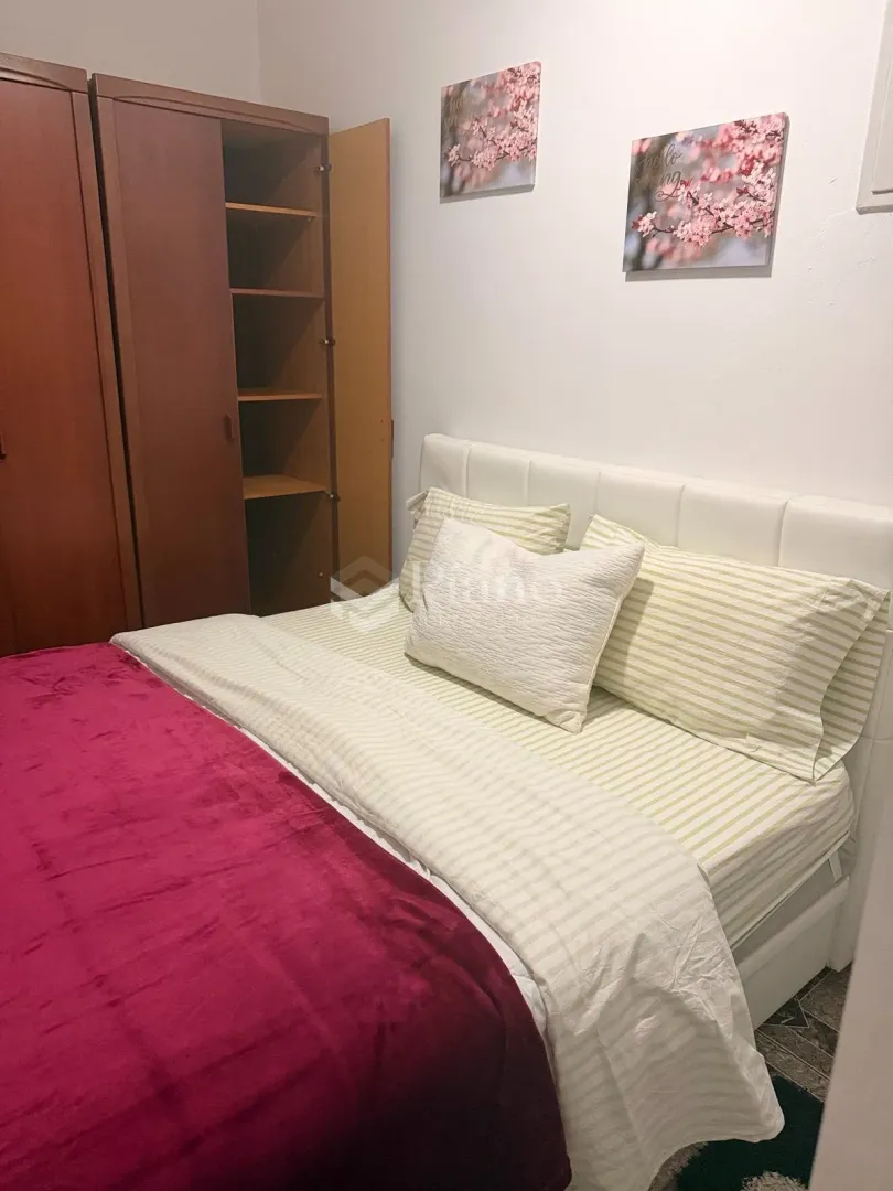 Bedroom with a double bed and a wooden wardrobe.