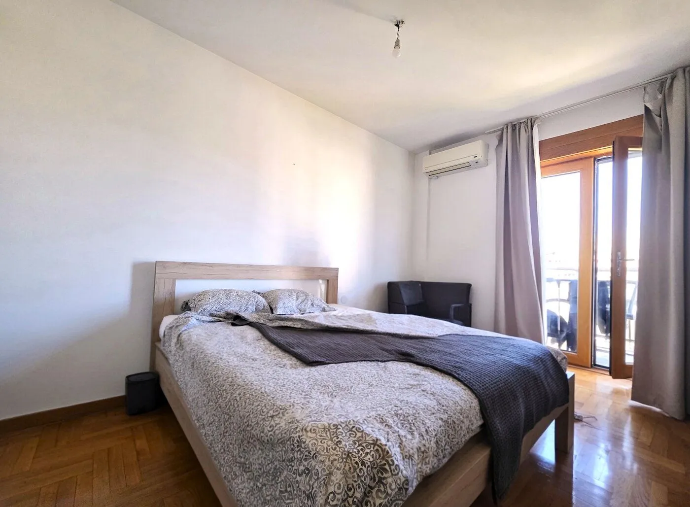 Spavaća soba sa bračnim krevetom i izlazom na terasu.